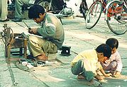 Father works, children play on pavement.