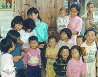 Chinese children gather at open street door.