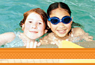 two children smiling during swim lessons