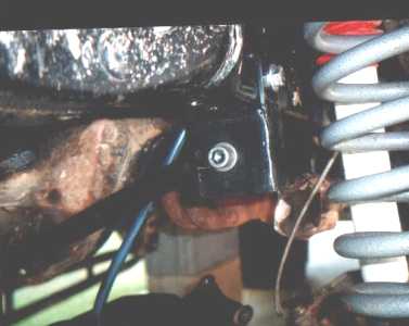 Track bar mount installed on frame next to coil spring