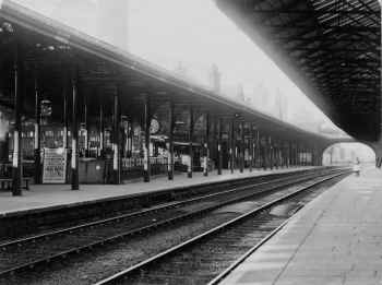 Carnforth Station. The placard proclaims that the "Swan Hotel", Newby Bridge is to be sold by Auction on 11th June 1901. Thomas Rathbone collection.