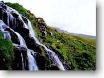 One of many waterfalls in the area, Old Man of Storr on the horizon. The picture was taken not far from the place we had tents
