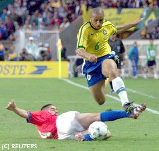 Roberto Carlos escapa por la banda, eludiendo la marca de su adversario