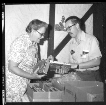 Mae looks over Ned's books