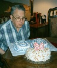 James blows out the candles on his 80th Birthday Cake