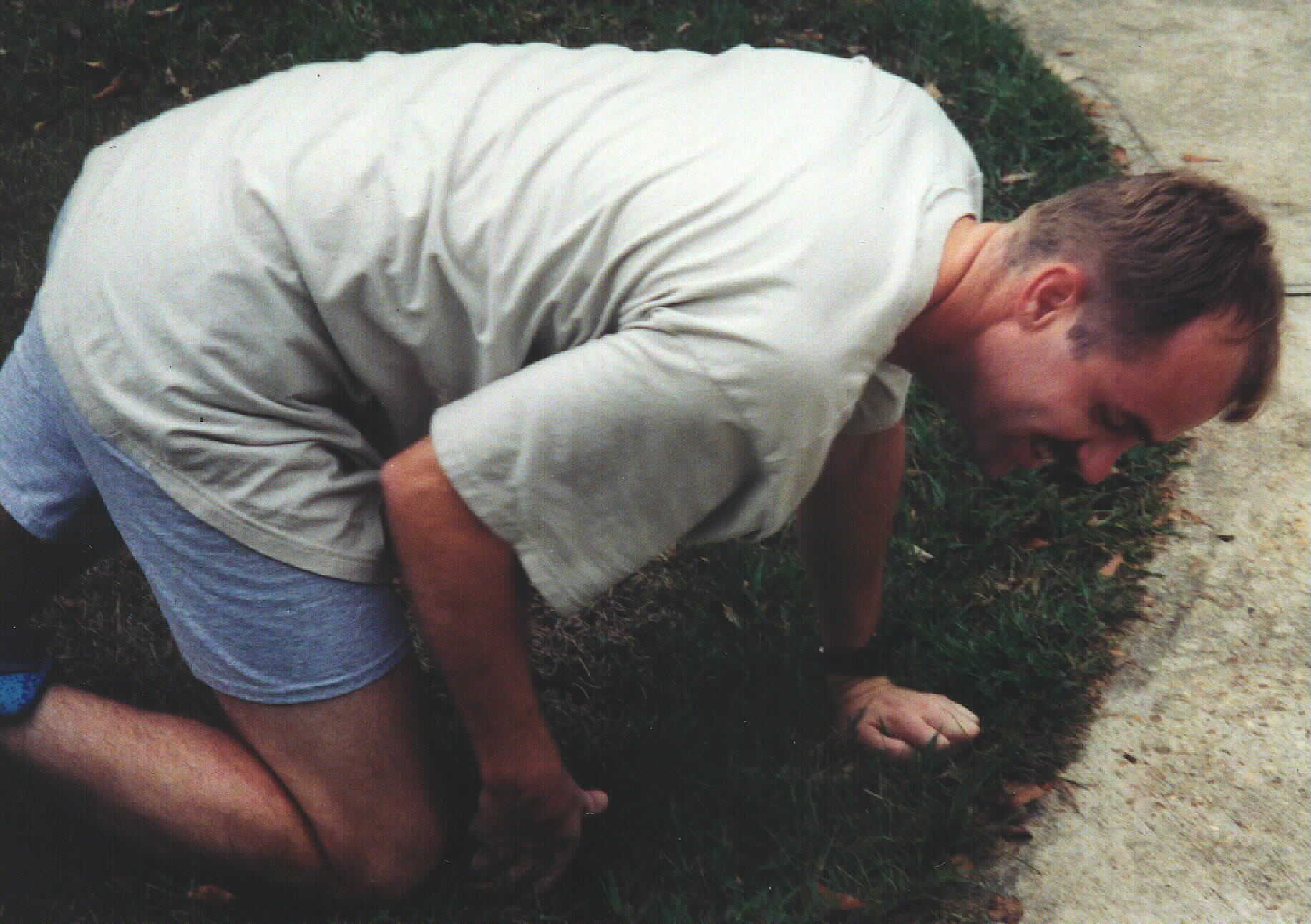 daddy falls on his knees in the grass