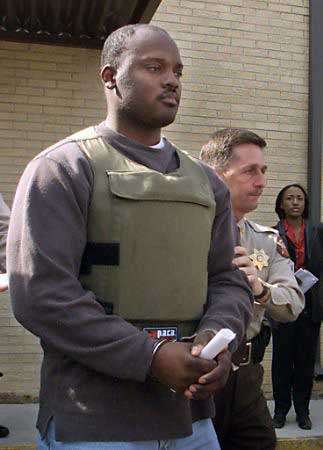 Ray Brent Marsh, the operator of a Georgia crematory accused of charging for cremations and then dumping the bodies on his property, departs a bond hearing at the Walker County Courthouse February 22, 2002. Marsh, who police said had received a number of death threats and is wearing a buller proof vest, is charged with 16 counts of theft by deception. Photo by Tami Chappell/Reuters